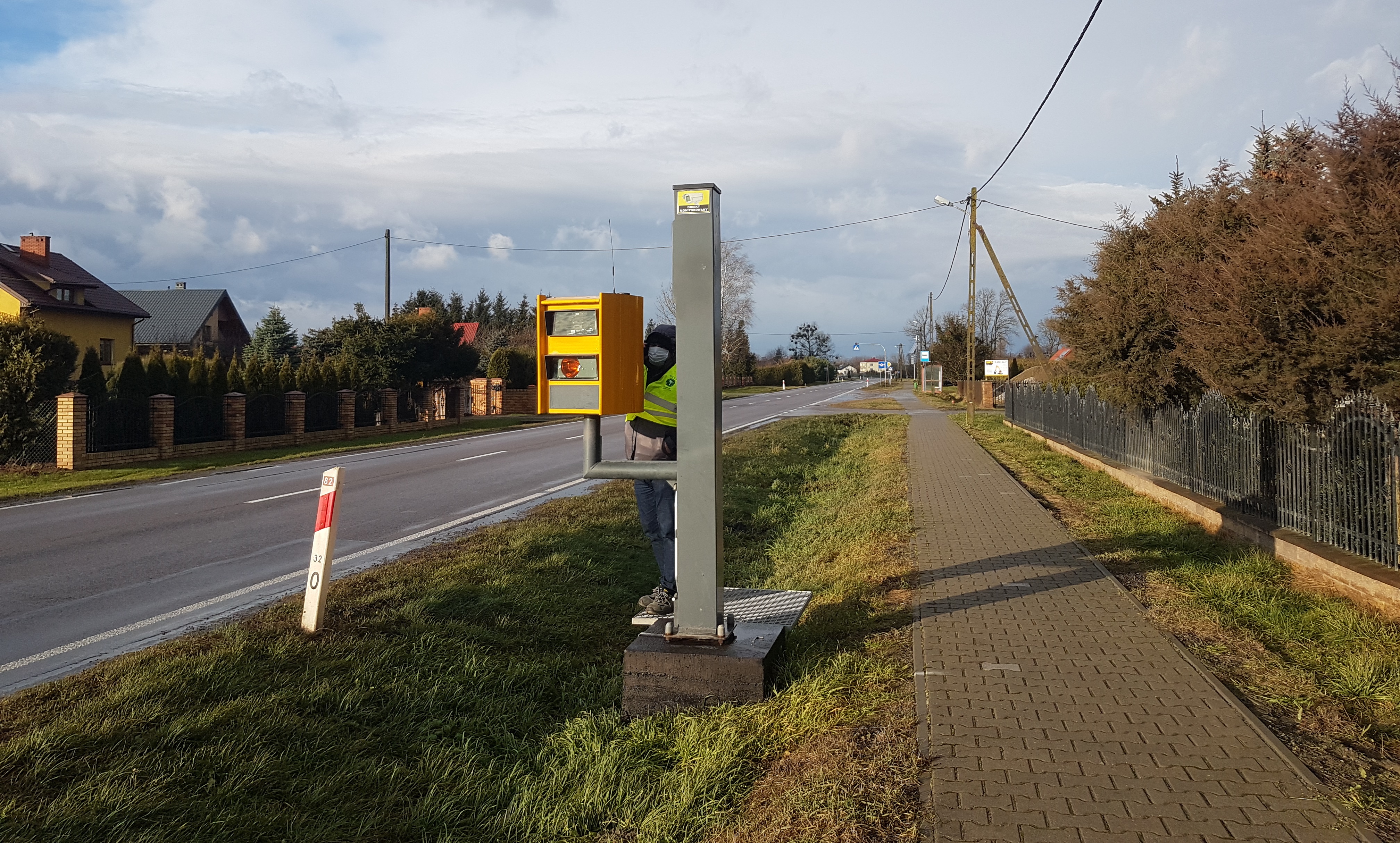 Operator urządzeń stojący przy fotoradarze w Brzezinach