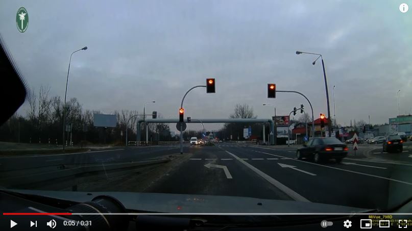 Okno wideo - samochód osobowy wjeżdzający na skrzyżowanie na czerwonym świetle