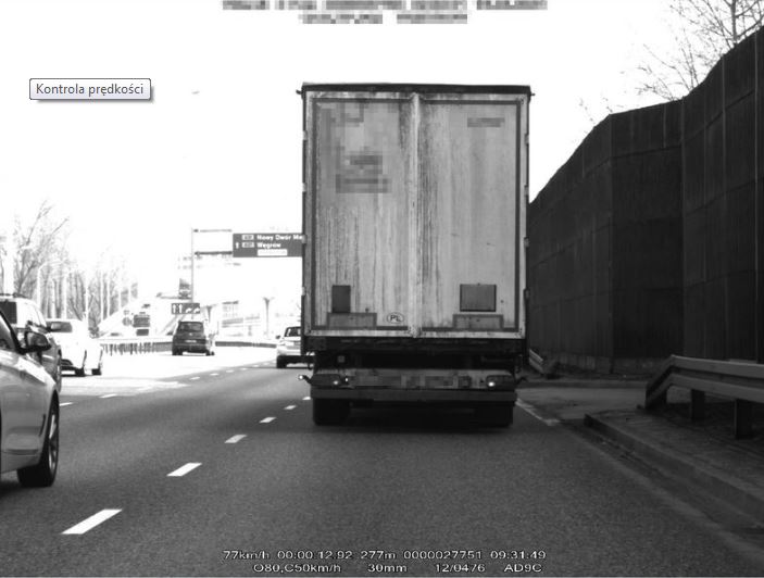 Zdjęcie cieżarówki jadacej przed radiowozem